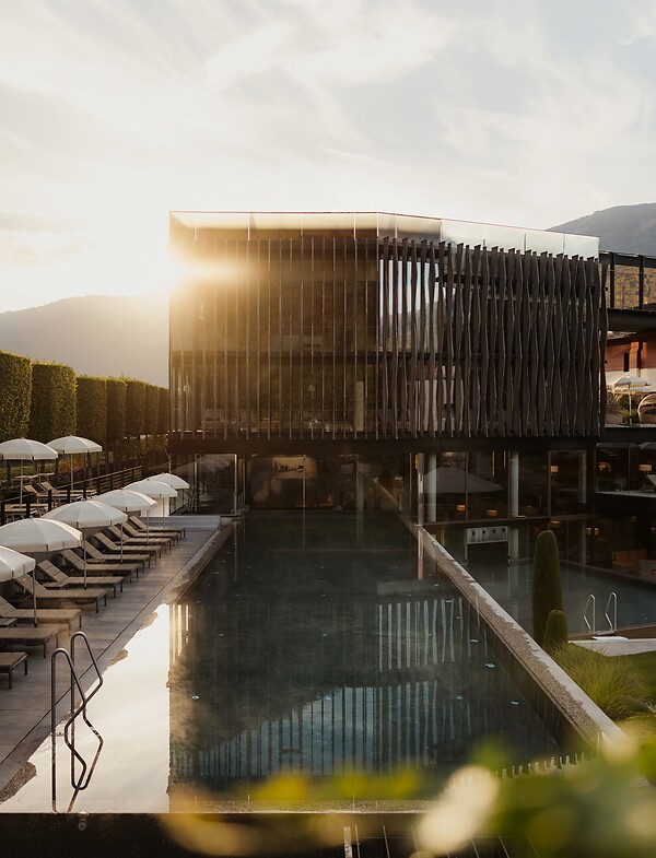 Wellnesstower mit Sportpool und Sonnenliegen bei Sonnenaufgang