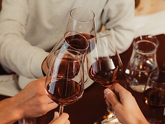 Beim Törggelen mit einem Glas Rotwein anstoßen