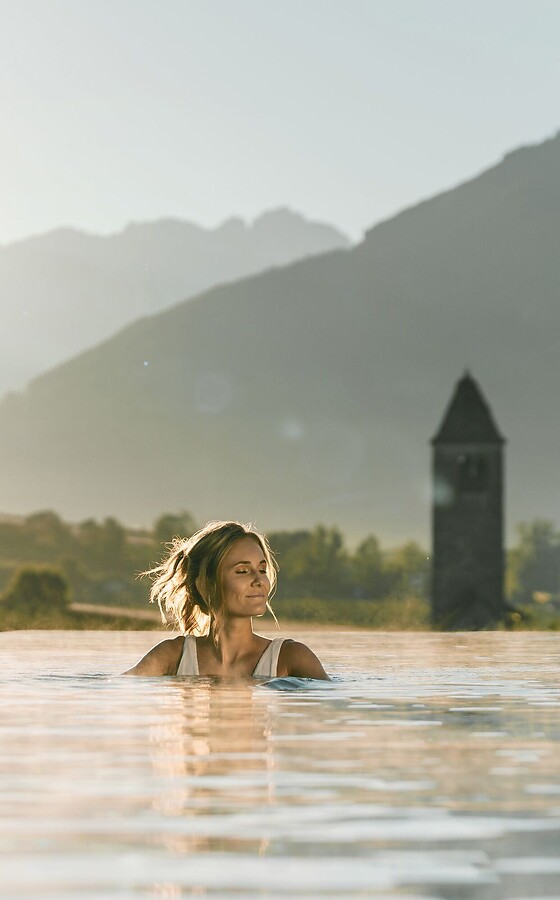 Frau im Sky Infinity Pool bei Sonnenaufgang