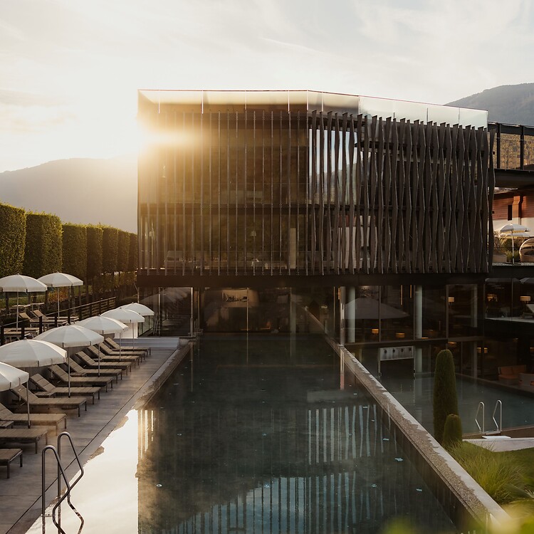 Wellnesstower mit Sportpool und Sonnenliegen bei Sonnenaufgang